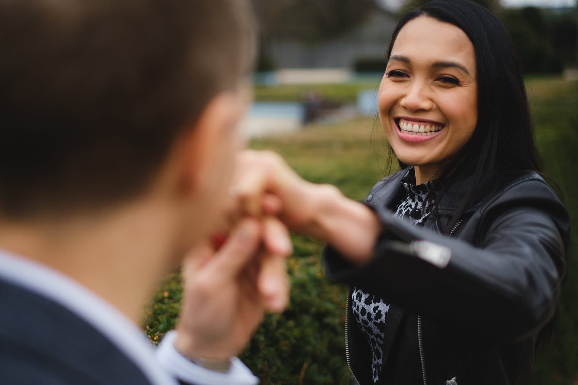 a woman taking her fiance's hand in Battersea park during an London engagement photography session