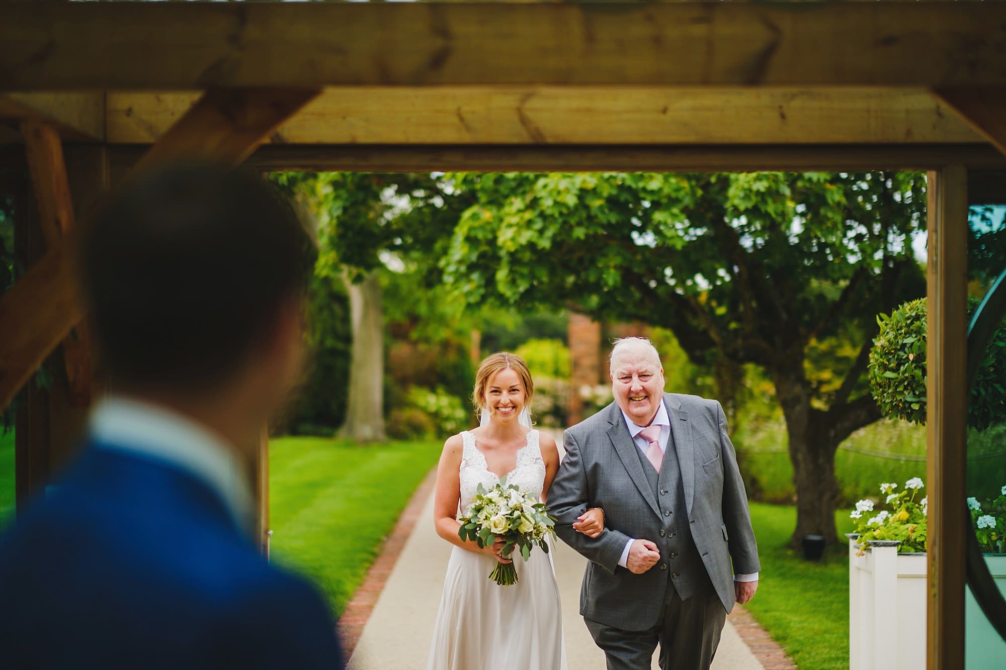 bride and father of the bride arrive at the wedding ceremony at gaynes park