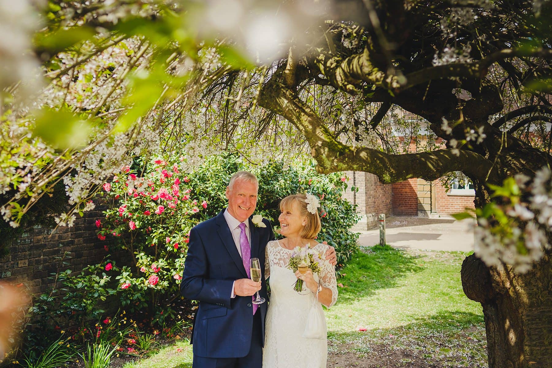 bride and groom under a blossom tree at york house