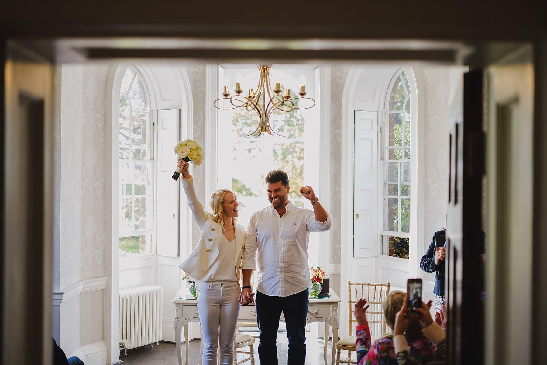 bride and groom celebrate after marrying in the sheridan room at morden park house